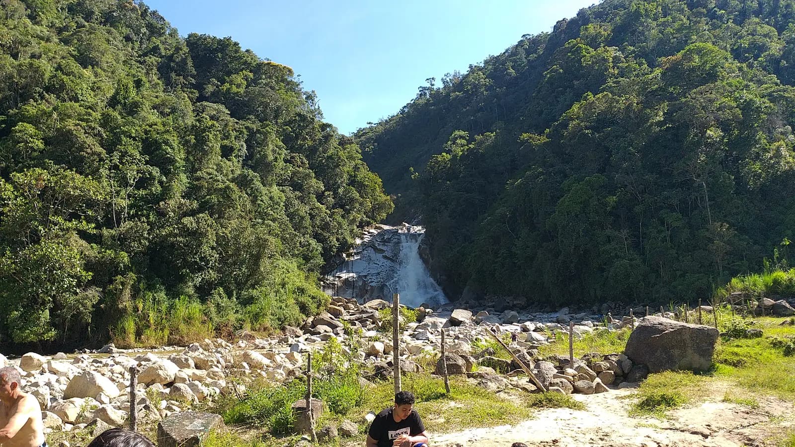 A rocky waterfall pool surrounded by green hills near Alejandría