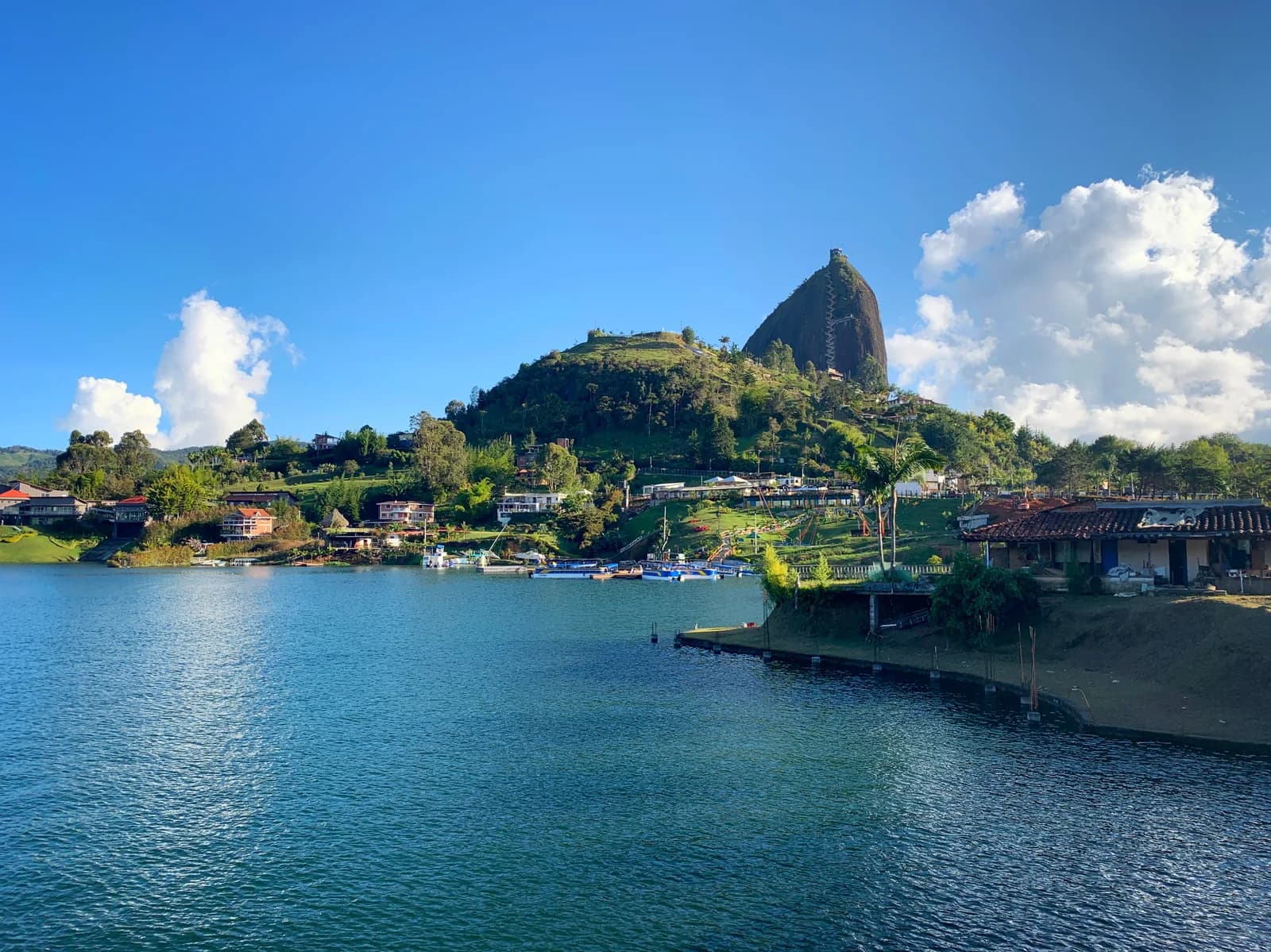 The rock of El Peñón rising behind the Guatapé reservoir on a sunny day