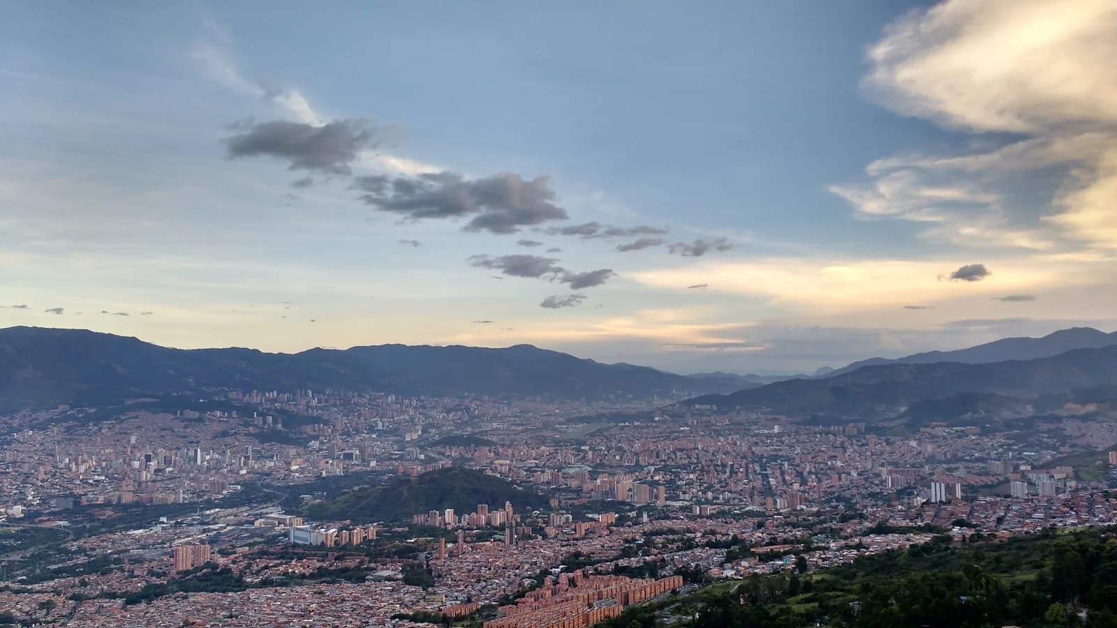 The city of Medellín filling its valley beneath a wide evening sky