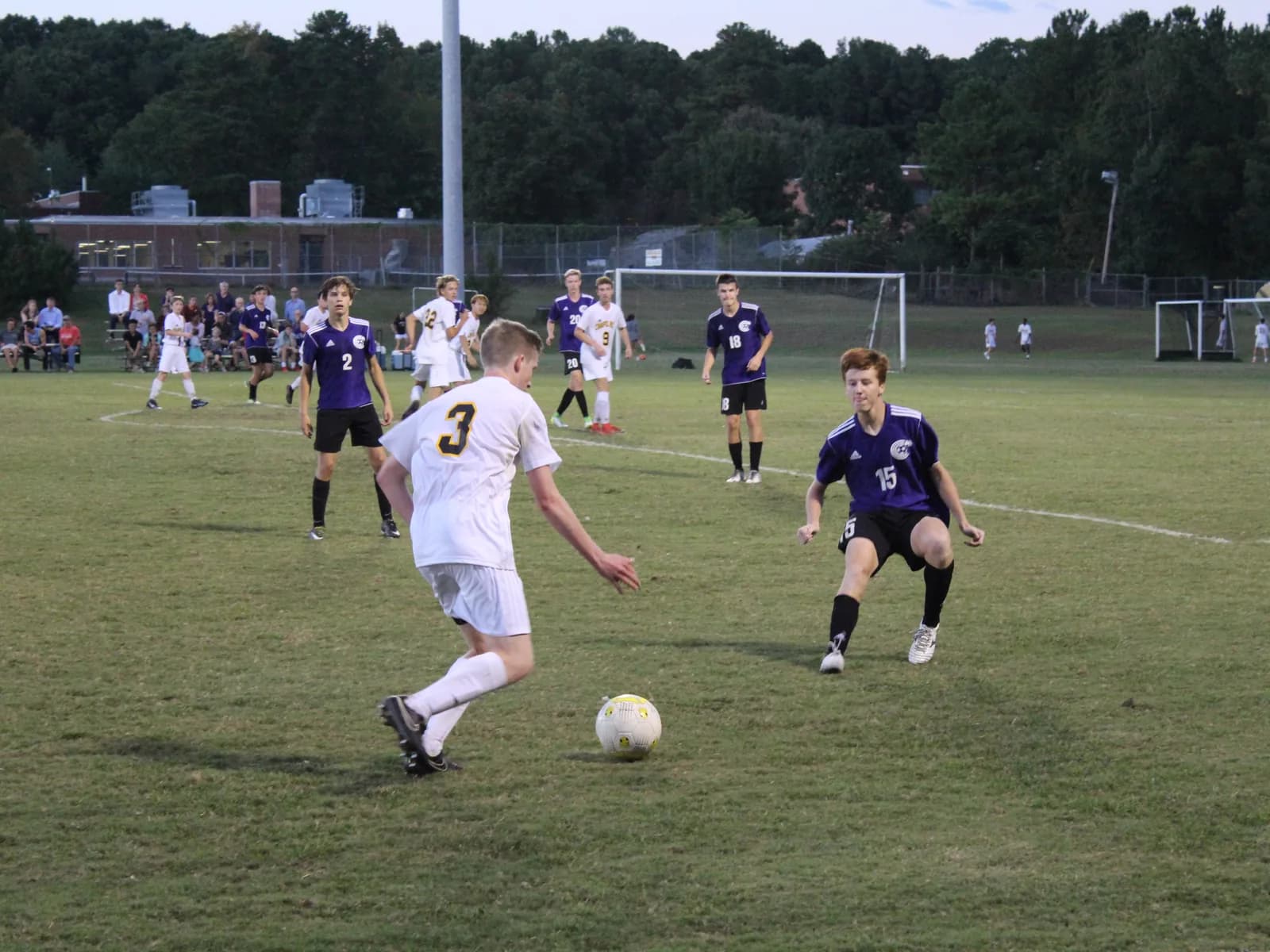 Teenage boys contesting the ball during a high-school soccer match