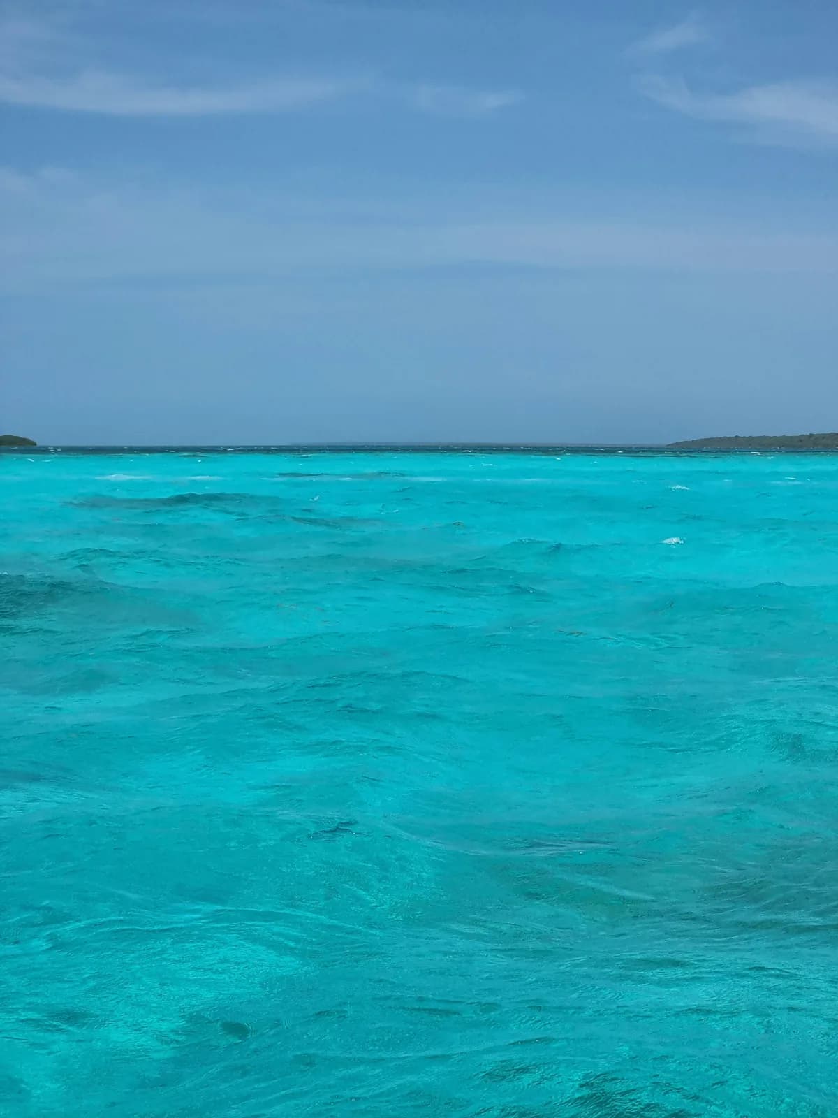 Clear turquoise sea meeting a calm blue horizon