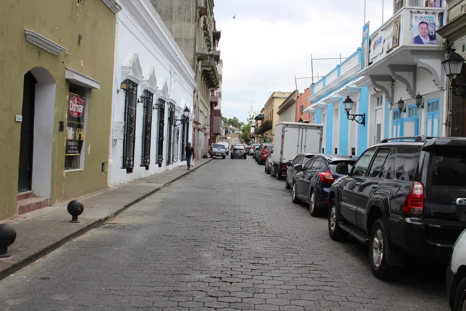 A cobbled street lined with colourful colonial buildings