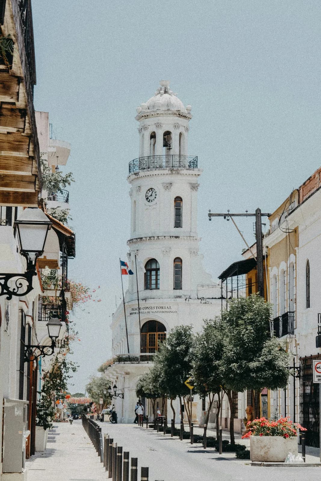 A white church tower above a narrow historic street