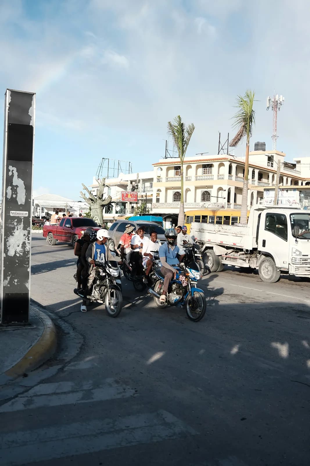 People and traffic moving through a Dominican city street