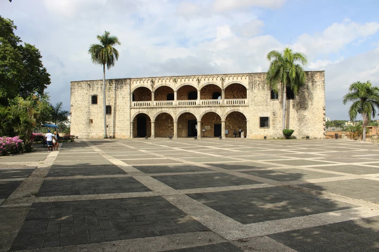 A historic stone building with two levels of arched galleries