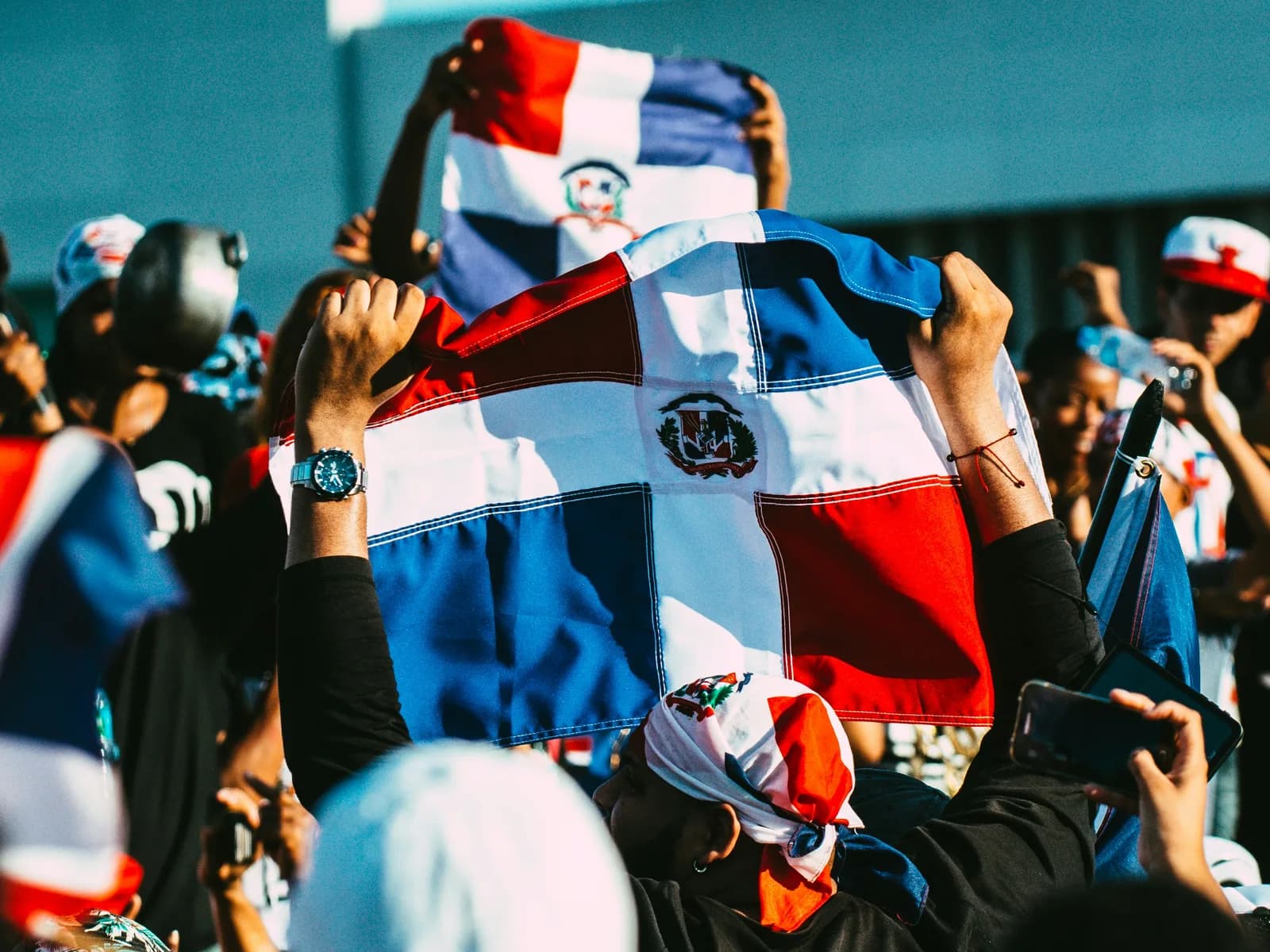 Fans holding Dominican flags high above a celebrating crowd