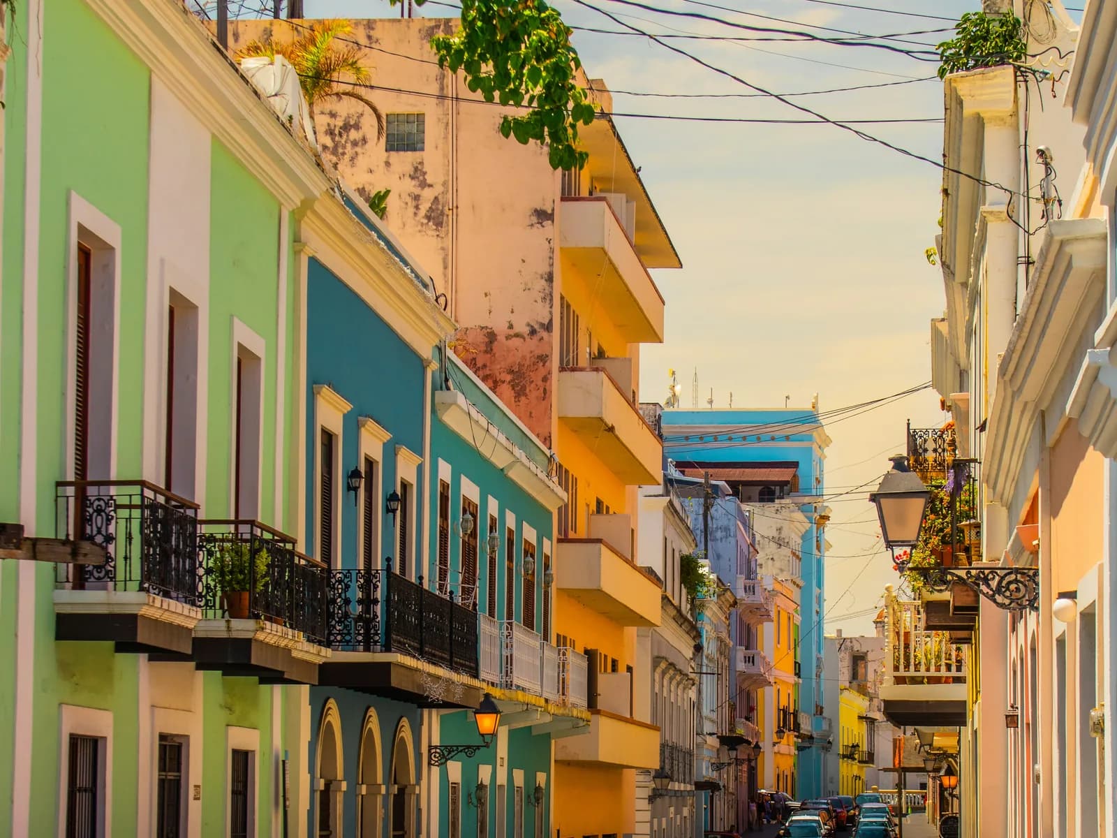 Pastel facades with iron balconies along a street in Old San Juan