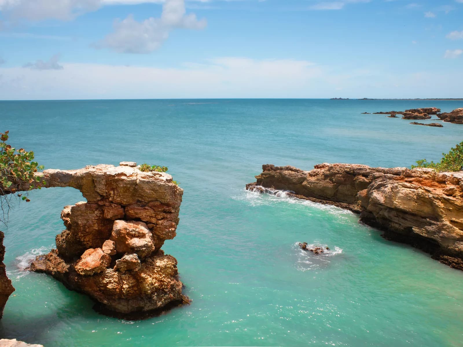 A natural rock arch standing in turquoise water off the Puerto Rico coast