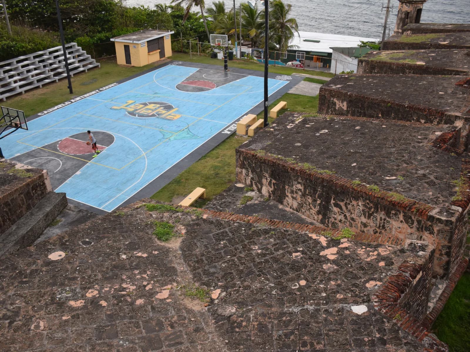 An outdoor basketball court between the old fortress walls of La Perla, San Juan