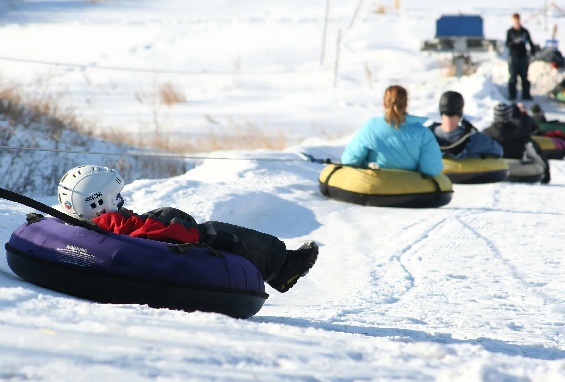 People enjoying snow tubing on a winter slope
